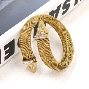 Close-up of gold mesh woven bracelet with crystal-studded triangle ends and polished finish