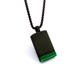 Macro detail of rectangle black metal pendant with green malachite stone inlay