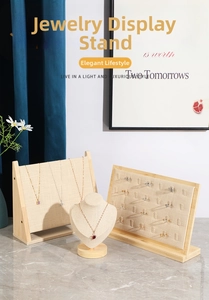 Linen and bamboo jewelry display stands for necklaces and rings on marble surface