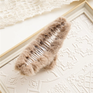 Close-up of soft light brown plush hair claw clip with transparent plastic teeth