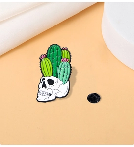 Detail of creative punk enamel pin with cactus skull design and black rubber back clasp
