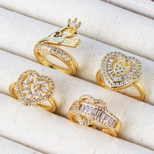 Gold plated ring set of four featuring heart and zircon designs in white jewelry box