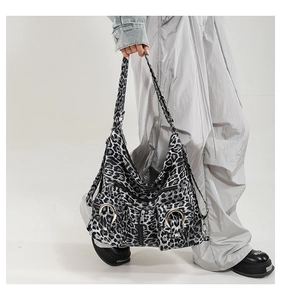Detail showing the gray leopard print tote bag with functional pockets and zippers
