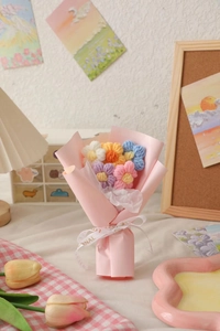 Hand-knitted flower bouquet with colorful puff petals and pink gift wrap detail