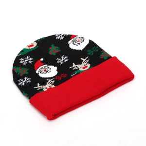 Dettaglio del berretto natalizio a maglia con motivi di Babbo Natale e renne nere