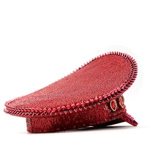 Detail of red sequined captain hat with punk studs and large heart gemstones