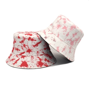 Detail view of tie-dye bucket hats in pink and red with reinforced stitching on the brim