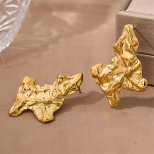 Irregular geometric earrings with gold finish and crushed lava texture in modern style
