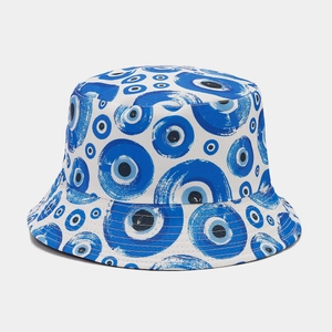 Vista dettagliata del cappello da pescatore reversibile con motivi occhio blu su tela bianca