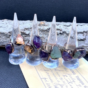 Close-up of raw amethyst and citrine stones set on vintage bronze adjustable rings