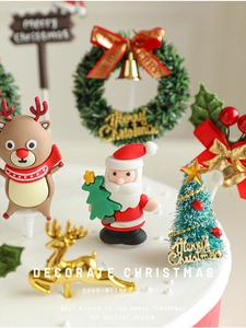 Macro shot of 3D Santa and reindeer cake toppers with Merry Christmas sign