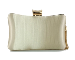Close-up of champagne gold evening clutch featuring silk texture and metallic tassels