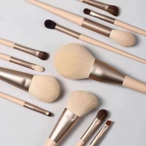 Detailed flat lay of 12 Morandi makeup brushes with wooden handles and rose gold ferrules