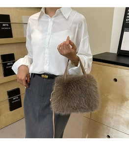 Close-up of a brown faux fox fur handbag with a slim khaki leather handle for women