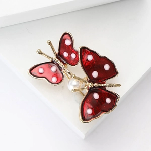 Elegant gold alloy double butterfly brooch with red enamel and pearl on white stand