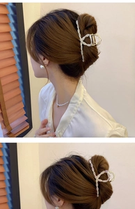 Detail view of elegant bow hair claw clip with white pearls on model for high-end styling