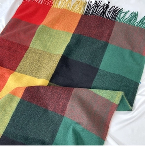 Detail of colorful plaid scarf showing soft cashmere-like texture and long fringed edges