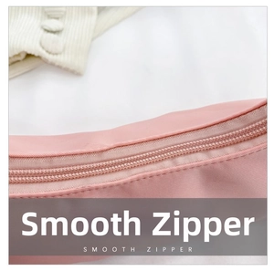 Close-up of a smooth high-quality metal zipper on a pink nylon crossbody bag