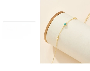 Detail of gold chain bracelet with turquoise and zircon featuring triple-layer gold plating