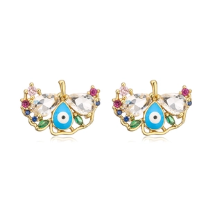 Macro view of gold evil eye stud earrings with blue enamel and sparkling zircon accents