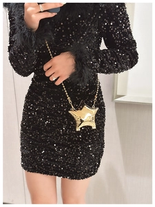Macro detail of glossy gold star shaped metal box bag with elegant chain strap