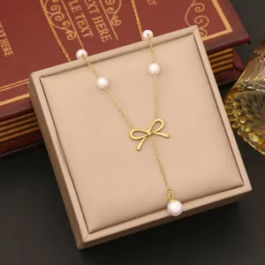 Close-up of golden bow necklace with pearl tassels in a luxury jewelry box