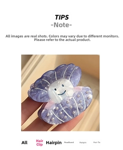 Detail of purple acetate shell hair claw clip with smiling face and pearl accent