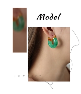Detail of emerald green resin U-shaped earrings with gold-plated titanium steel finish