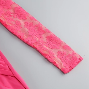 Detailed view of rose pink lace fabric with intricate rose patterns on dress sleeve