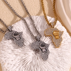 Detail of gold and silver African map pendants with crystal inlay and fist motif