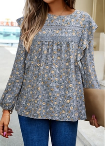 Detail of floral blouse with ruffled shoulders and delicate lace stitching accents