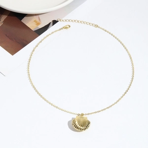Golden shell locket pendant necklace with fine chain and lobster clasp on white surface