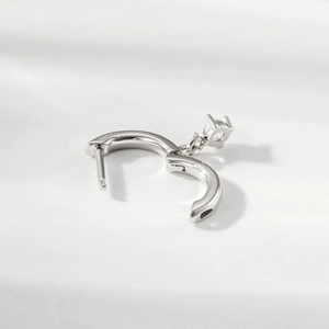 Minimalist silver heart earrings with sparkling diamond pendant on white background