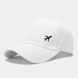 Détail de la broderie avion noir sur une casquette de baseball en coton blanc