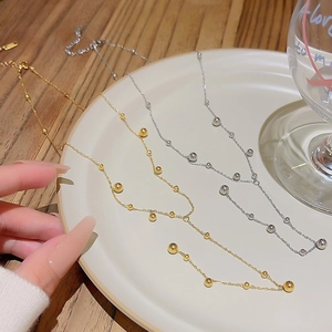 Elegant gold and silver beaded tassel necklaces displayed on a white ceramic plate