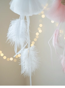 Close-up of white and pink jellyfish pendant with ostrich feathers and mesh for Christmas tree