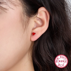 Elegant 925 sterling silver heart stud earrings with red enamel on female model