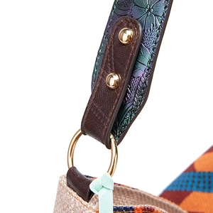 Detail of embossed floral leather strap and gold ring on bohemian woven bag