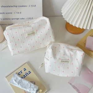 Detail of striped fabric makeup bags with pink heart patterns and zipper closure set