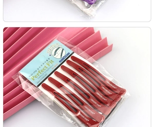 Close-up of six professional red hair styling sectioning clips in original packaging