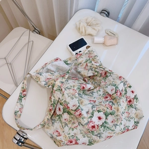 Detail of floral cotton tote bag featuring pink rose patterns and wide shoulder strap