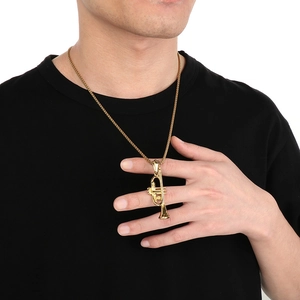 Golden trumpet musical instrument pendant worn on a black shirt for a vintage hip hop style