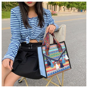 Detail of bohemian woven tote bag showing colorful geometric patterns and tassel charm