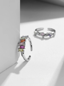 Detail of adjustable silver rings featuring baguette-cut rainbow cubic zirconia stones