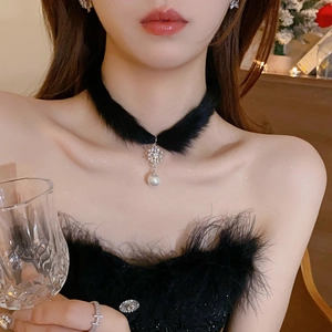 Détail d'un choker en peluche noire avec pendentif flocon de neige et perle sur modèle