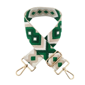 Detail of green rhombic jacquard wide strap with gold metal hooks and adjustable buckle