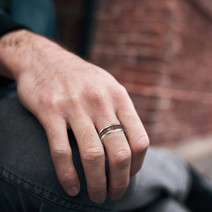 Bague pour homme en acier titane avec incrustation en teck sur la main du mannequin