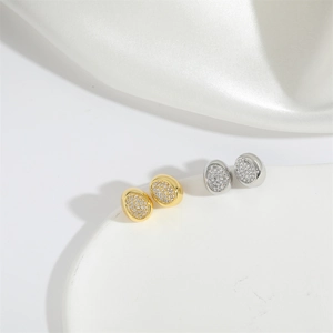 Close-up of gold and silver oval stud earrings with pavé rhinestones on white silk