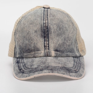 Detail of blue washed denim texture and beige breathable mesh on the baseball cap