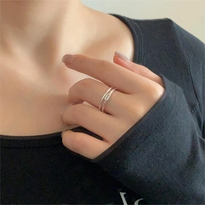 Minimalist double-layered silver ring with rectangular zircon shown on a model's finger